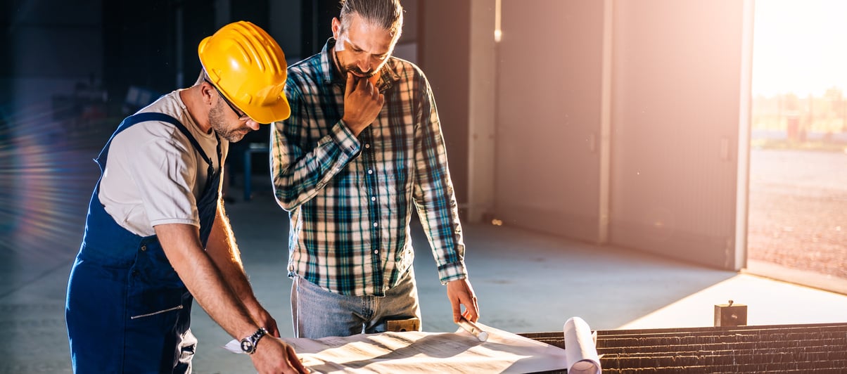 Construction workers checking checking blue print